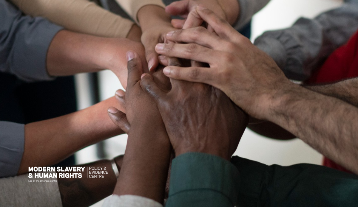 A photo of several hands on top of each other. In the bottom left corner is the text Modern Slavery and Human Rights Policy and Evidence Centre, led by the Bingham Centre.