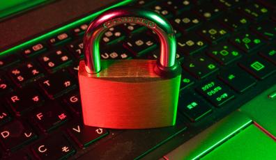 This photo shows a closed padlock resting on a computer keyboard.