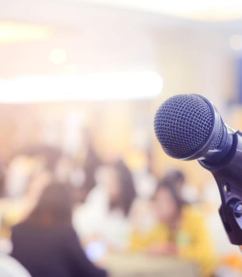 A microphone in front of a crowded meeting room